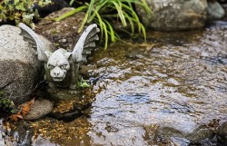 A winged gargoyle stands guard in this river 