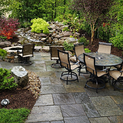 A small back yard accommodates a water feature, patio, and fire pit
